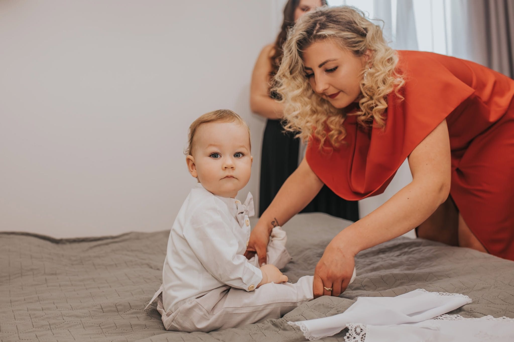 A baba mosolyog a keresztszülők karjaiban